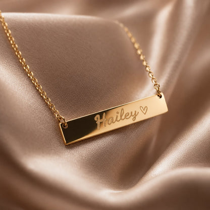 Close-up detail of engraved name bar necklace