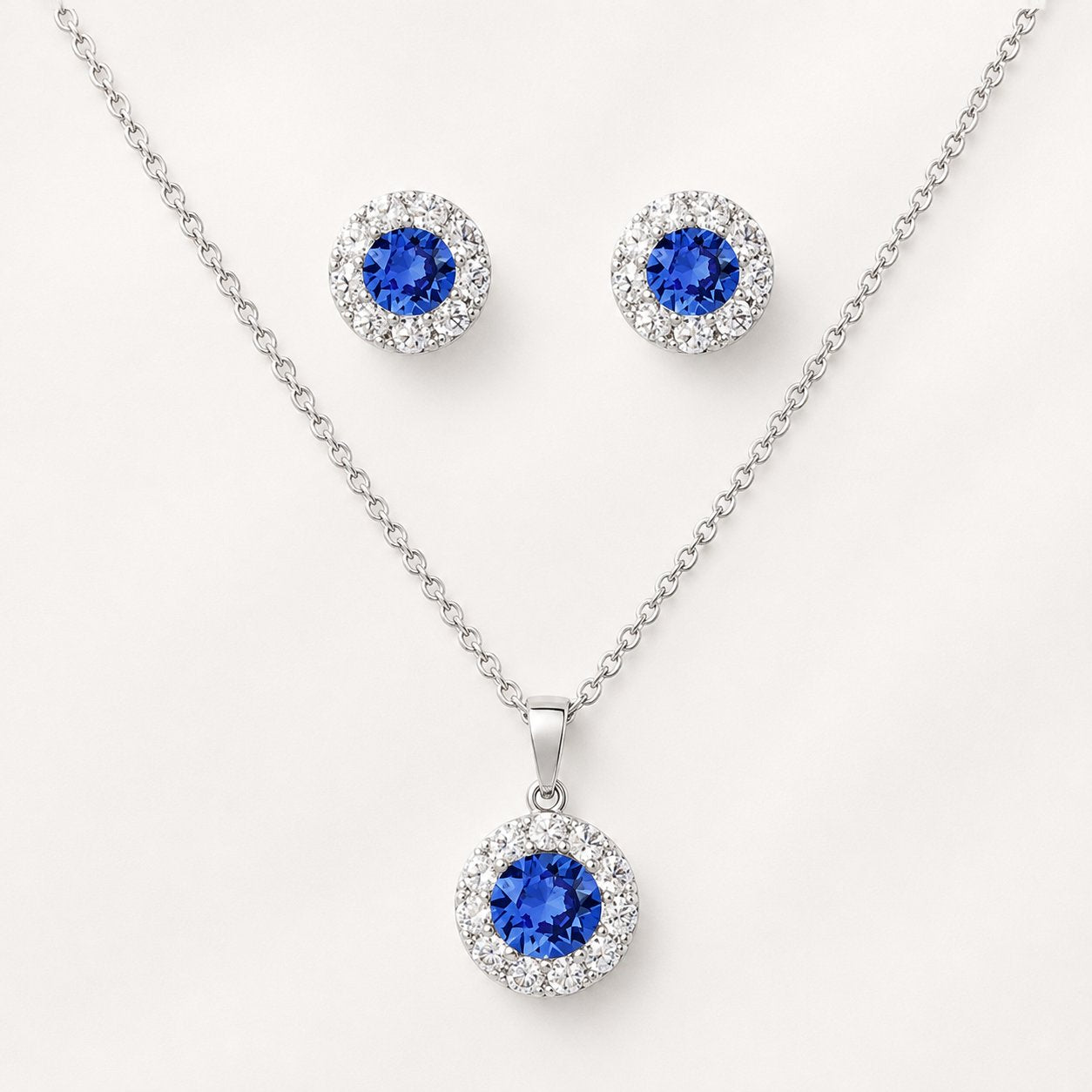 Celeste Sapphire Halo Set styled on satin fabric